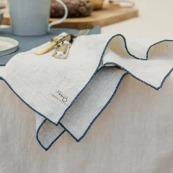 Set di 4 tovaglioli in lino naturale con orlo arrotolato blu pietra
