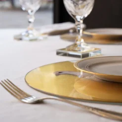 Sottopiatto rotondo Colomba su piedistallo in vetro grafite con sfondo in foglia oro